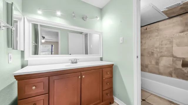 an empty room with wooden floor chandelier fan and windows