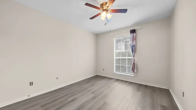 an empty room with wooden floor and white walls