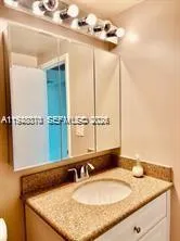 a bathroom with a granite countertop sink and a mirror