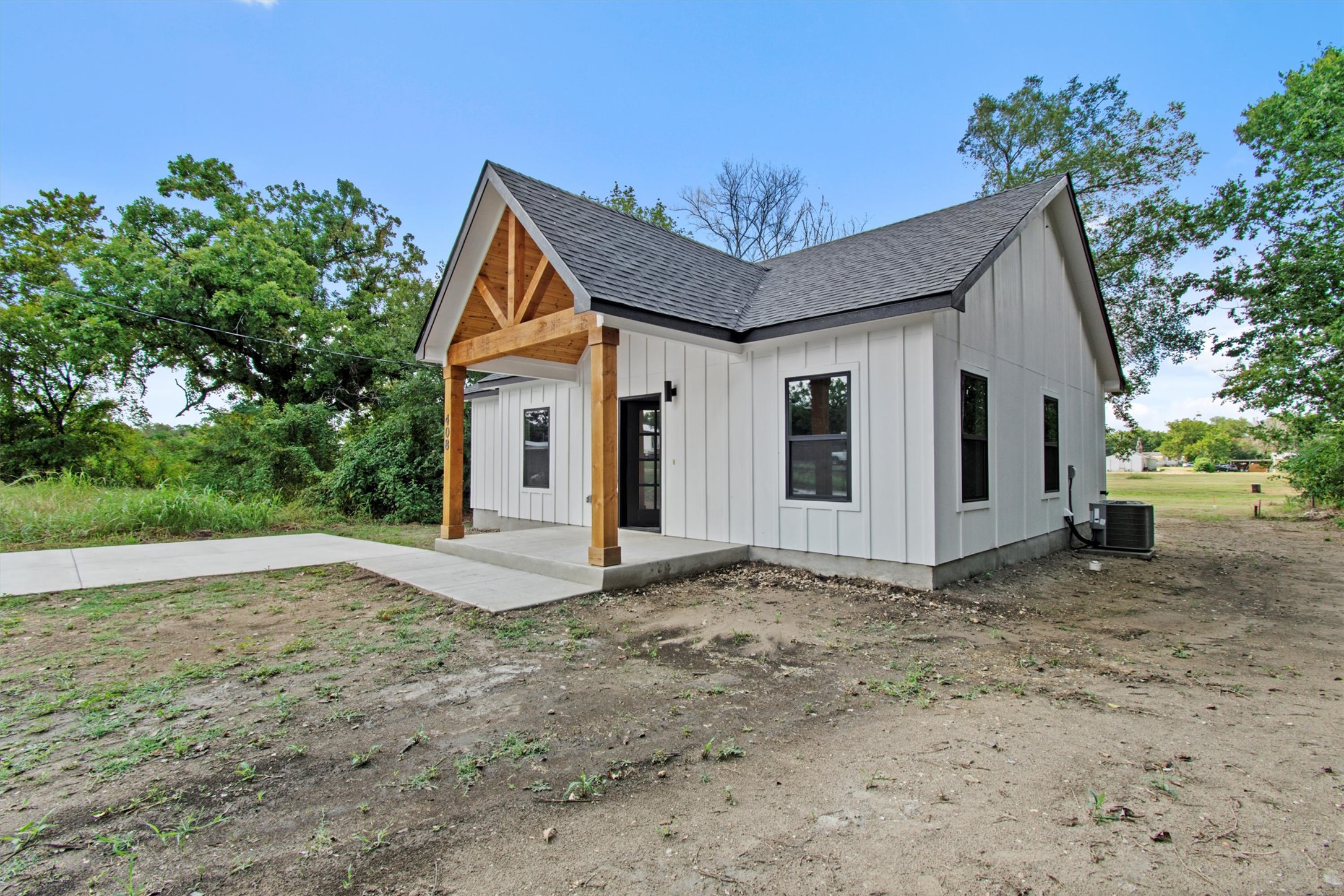 408 Griffin Street Luling, TX 78648 - Photo 3 of 34 Modern inspired farmhouse featuring board and batten siding, a shingled roof, and covered porch