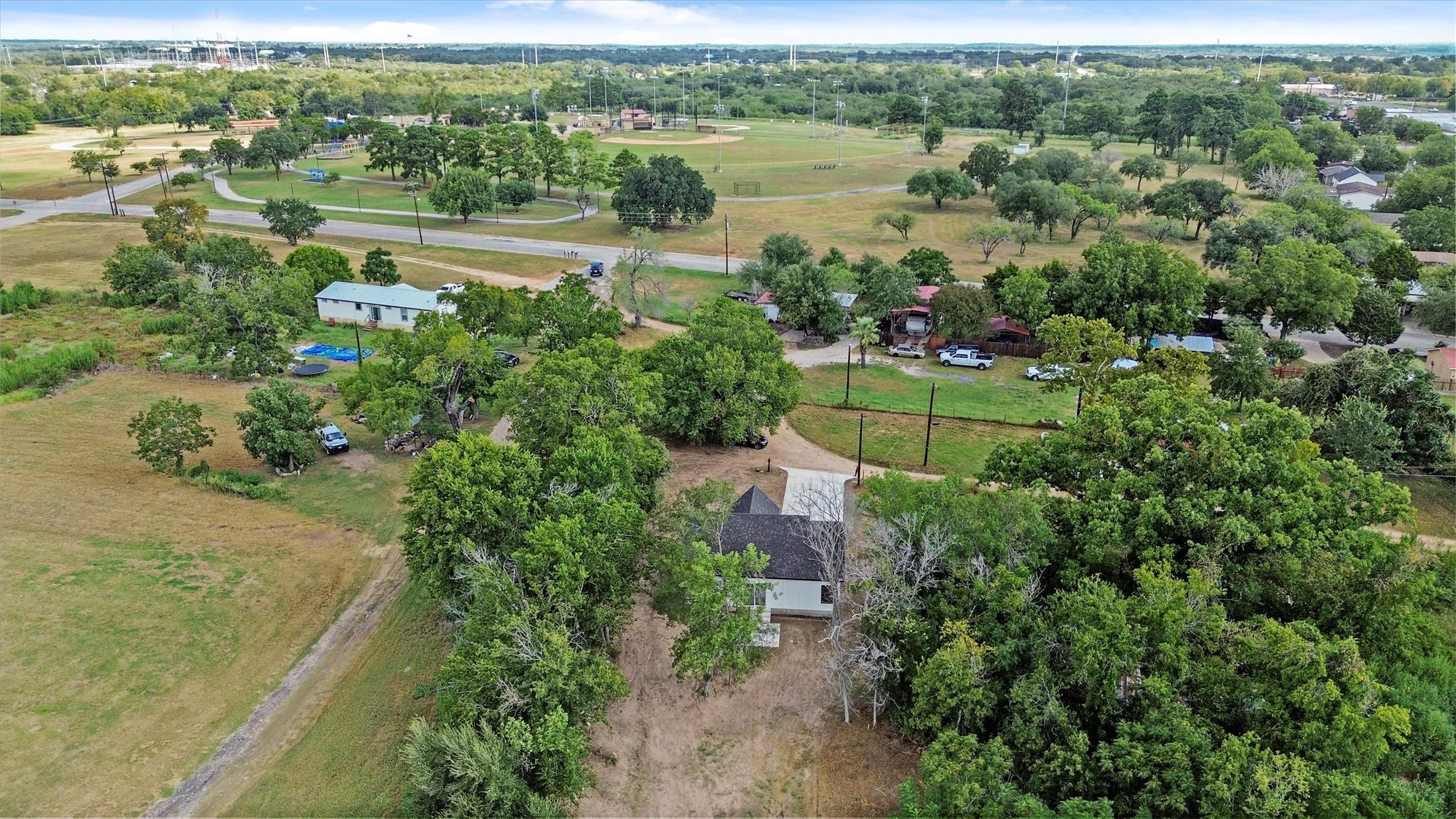 408 Griffin Street Luling, TX 78648 - Photo 33 of 34 Aerial overview of property's location with a tree filled landscape