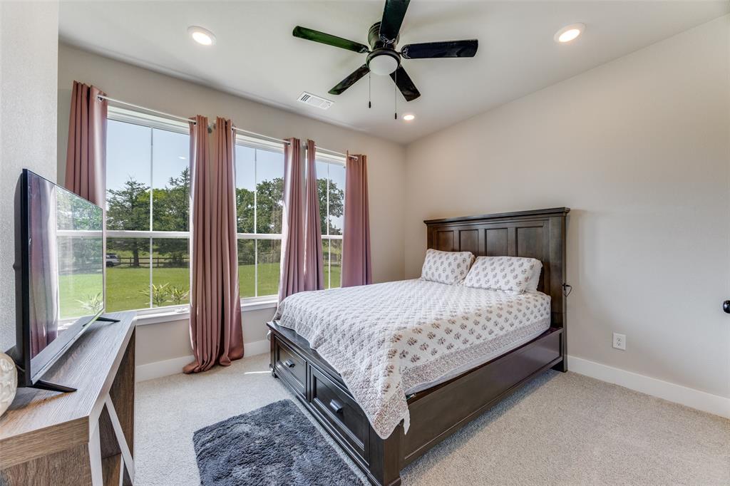 9425 Dripping Springs Road Denison, TX 75021 - Photo 23 of 39 a bed sitting in a spacious bedroom next to a window