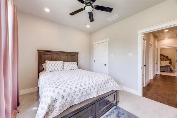a bed sitting in a spacious bedroom next to a window