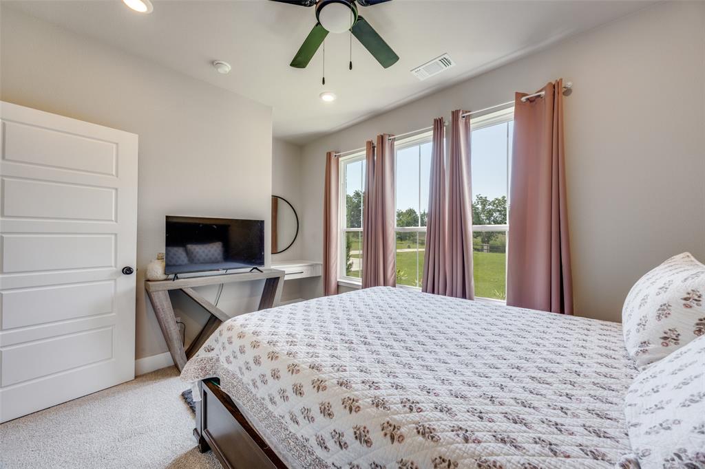 9425 Dripping Springs Road Denison, TX 75021 - Photo 25 of 39 a bedroom with a bed and a flat screen tv