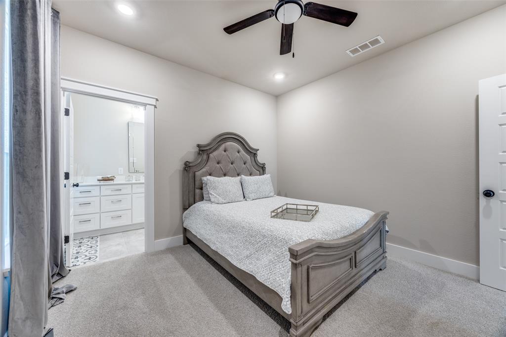 9425 Dripping Springs Road Denison, TX 75021 - Photo 28 of 39 a bedroom with a bed and a chandelier