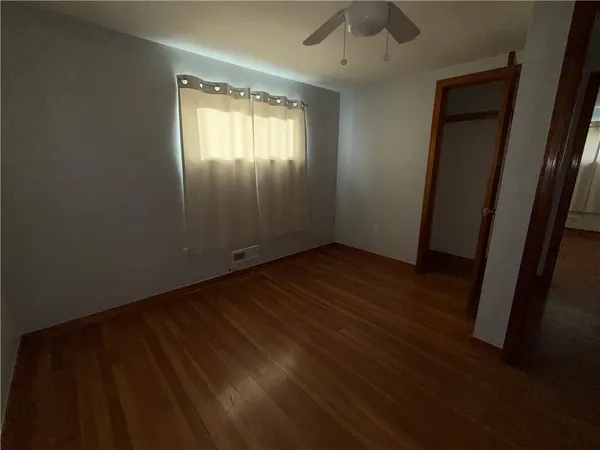 an empty room with wooden floor and a window