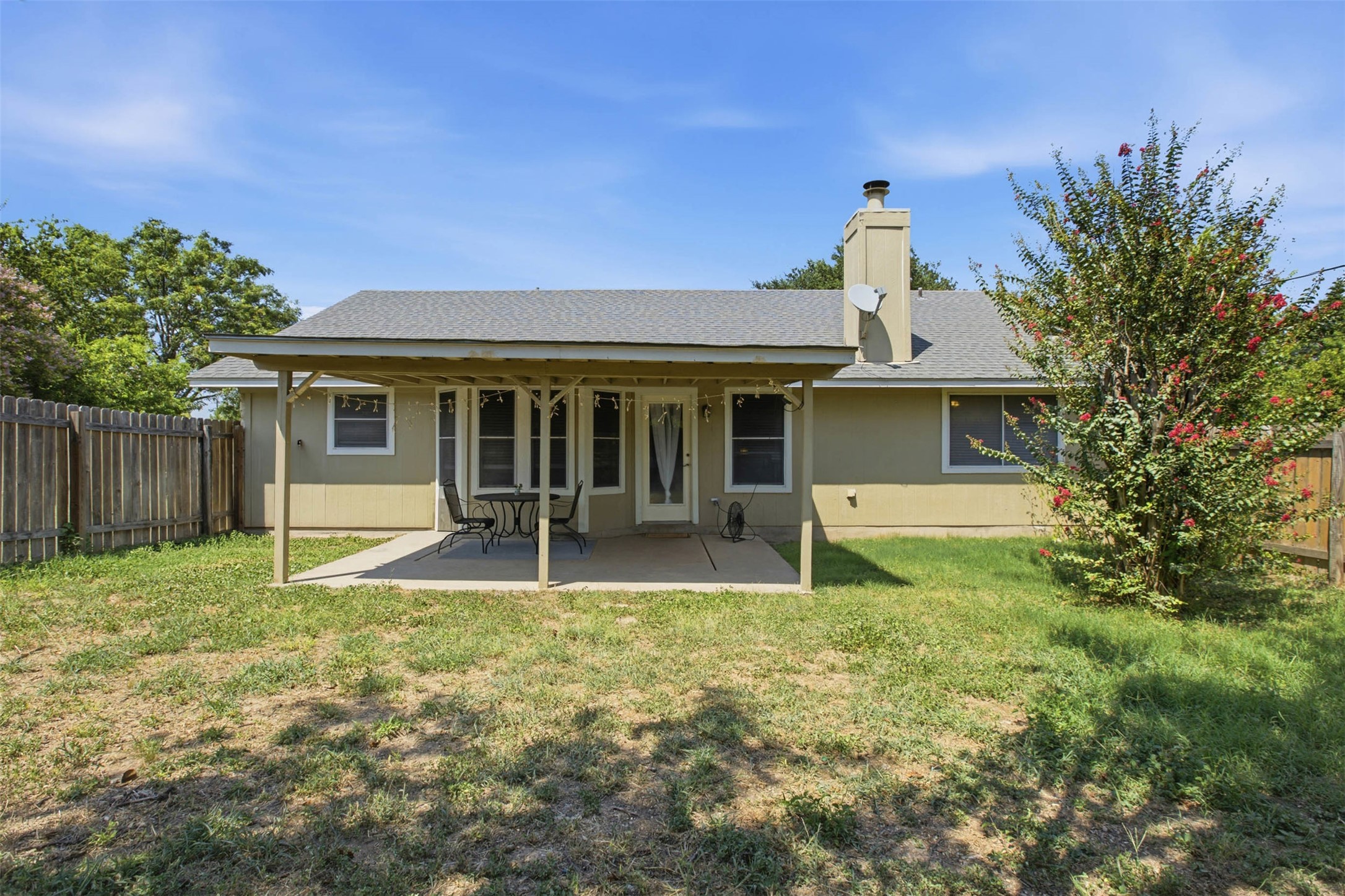 1717 Rendova Lane Pflugerville, TX 78660 - Photo 22 of 32 An inviting covered patio extends from this home's rear elevation, offering a pleasant outdoor living space within a fenced yard.