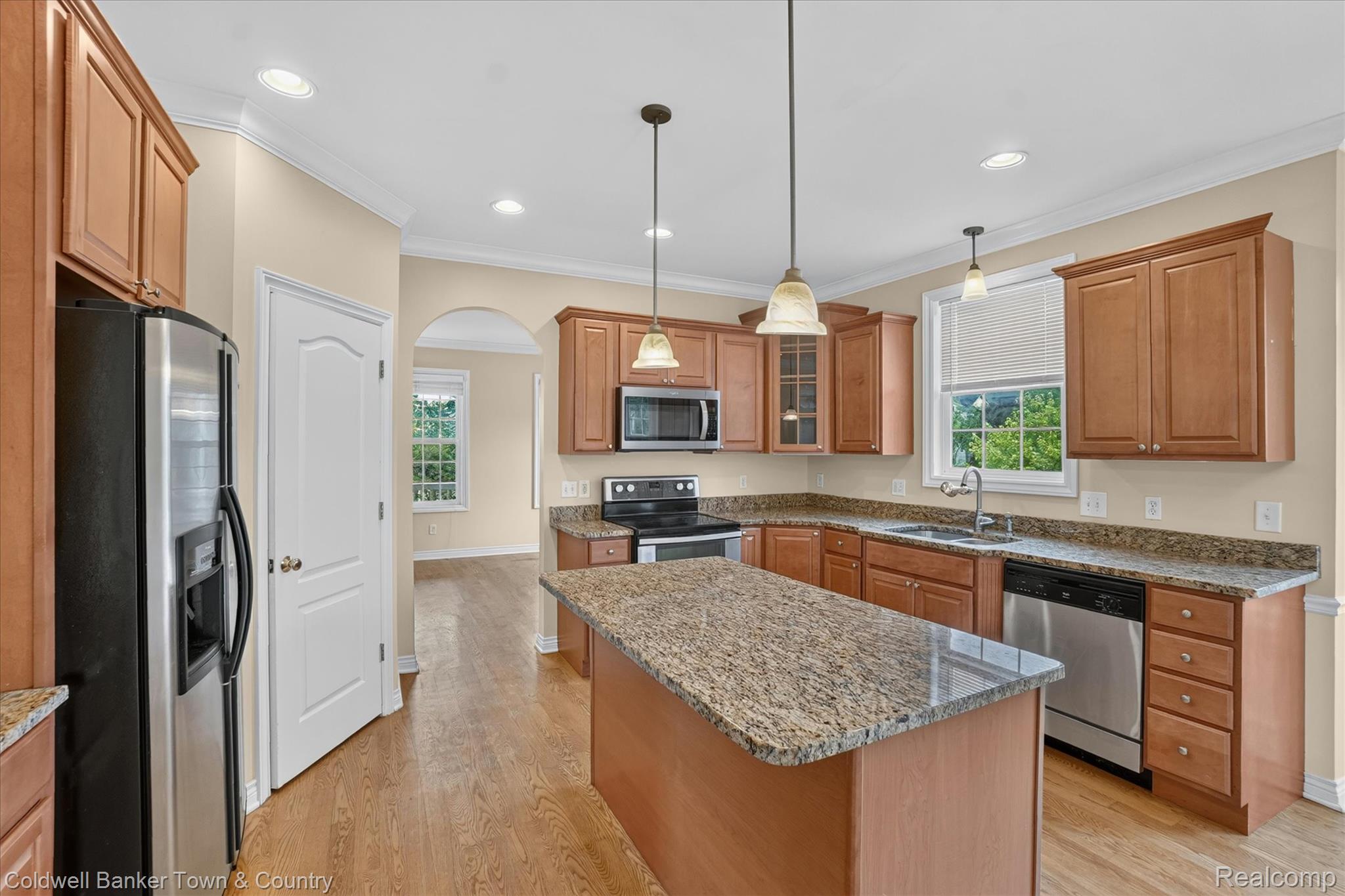 1725 Town Commons Drive Howell, MI 48855 - Photo 18 of 53 Kitchen featuring a central island with a stone-finish countertop, stainless steel appliances, wood-finish cabinetry, and recessed lighting