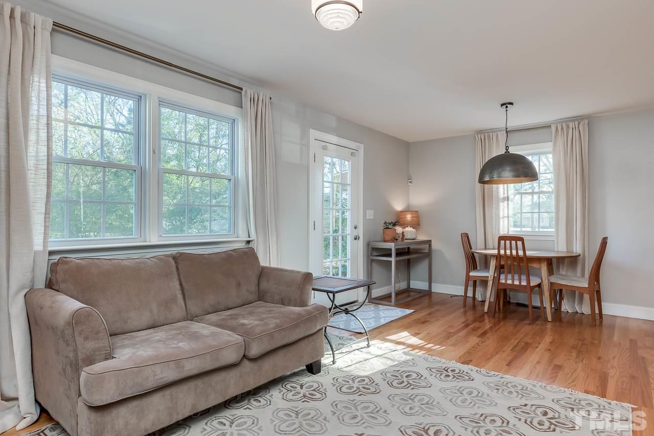 2411 Boswell Road Raleigh, NC 27610 - Photo 12 of 26 a living room with furniture a dining table and a wooden floor
