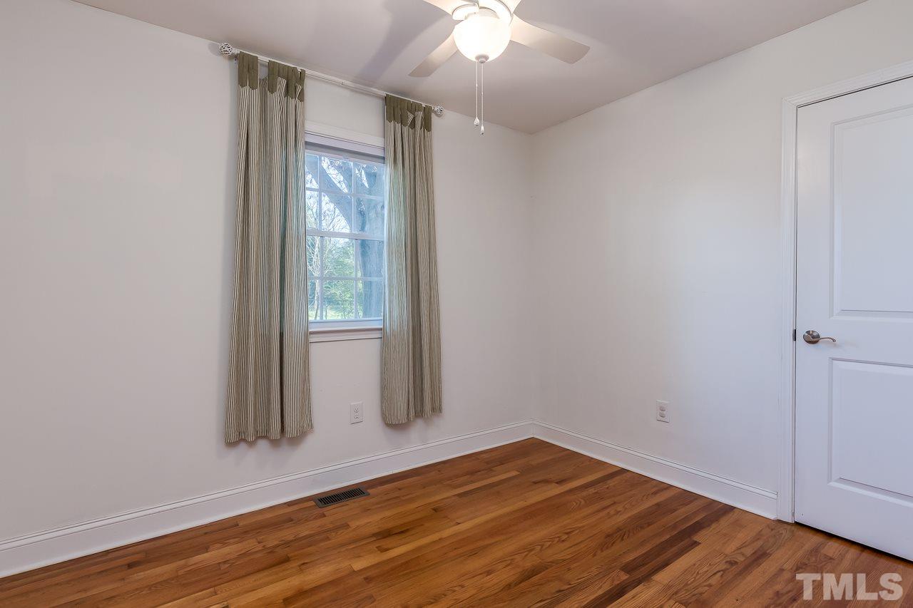 2411 Boswell Road Raleigh, NC 27610 - Photo 21 of 26 an empty room with wooden floor and windows
