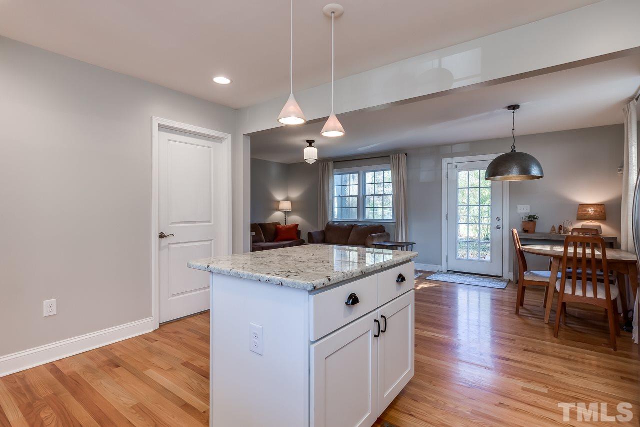 2411 Boswell Road Raleigh, NC 27610 - Photo 10 of 26 a kitchen with granite countertop cabinets a dining table and chairs with wooden floor