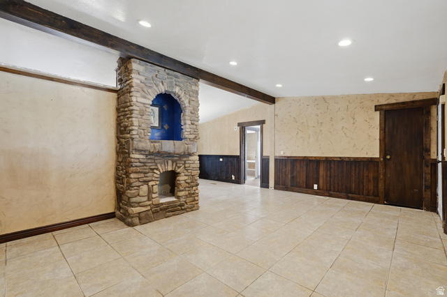 2875 North Hill Field Road, Unit 111 Layton, UT 84041 - Photo 6 of 30 Unfurnished living room with wainscoting, lofted ceiling with beams, recessed lighting, and light tile patterned floors