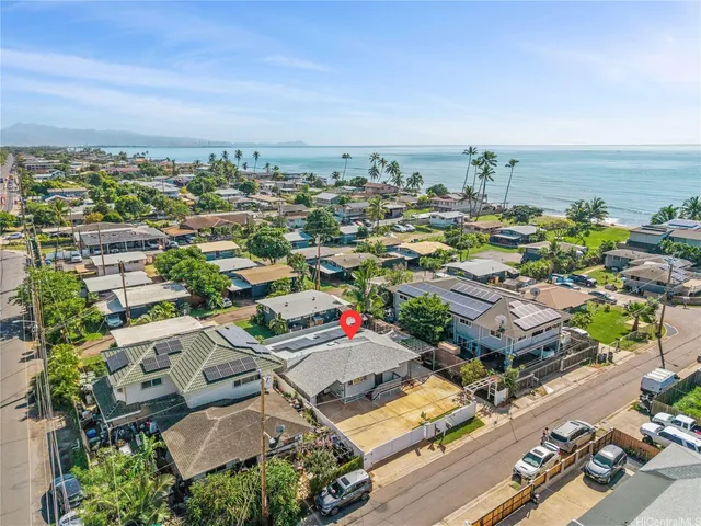 an aerial view of a city with lots of residential buildings and ocean view in back