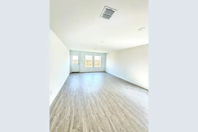 a view of wooden floor and windows in a room