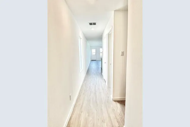 a view of a hallway with wooden floor
