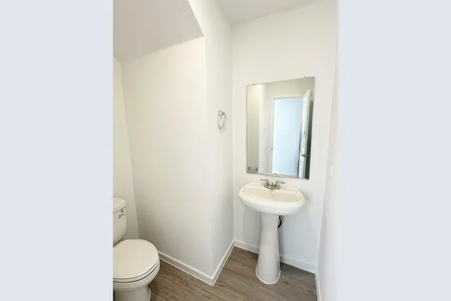 a bathroom with a sink toilet and a mirror