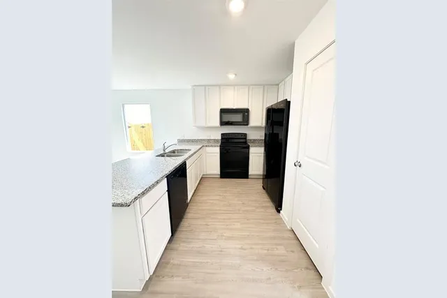 a kitchen with stainless steel appliances a sink and a refrigerator
