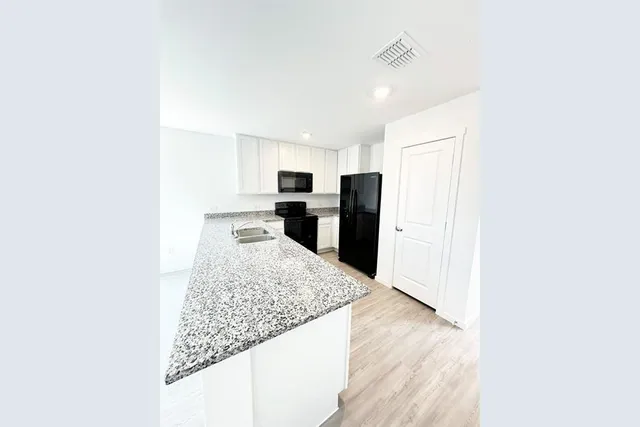 a kitchen with stainless steel appliances granite countertop a sink refrigerator and microwave