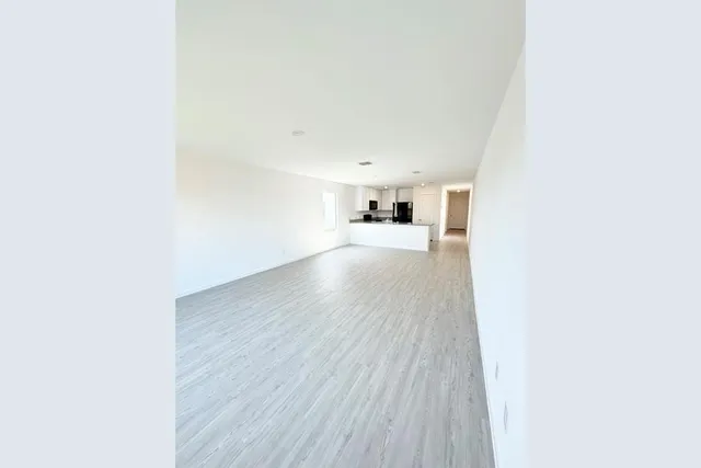 a view of a big room with wooden floor and windows