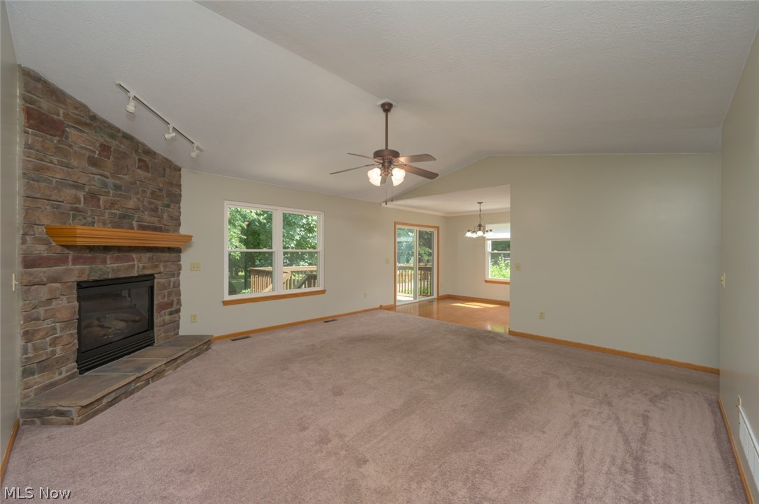 1048 Susan Road Ravenna, OH 44266 - Photo 21 of 35 Spacious living area featuring a stone-clad fireplace with a wood mantel, track lighting, and a ceiling fan