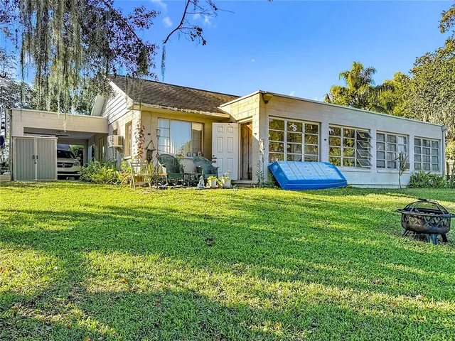 a view of a house with pool and sitting area