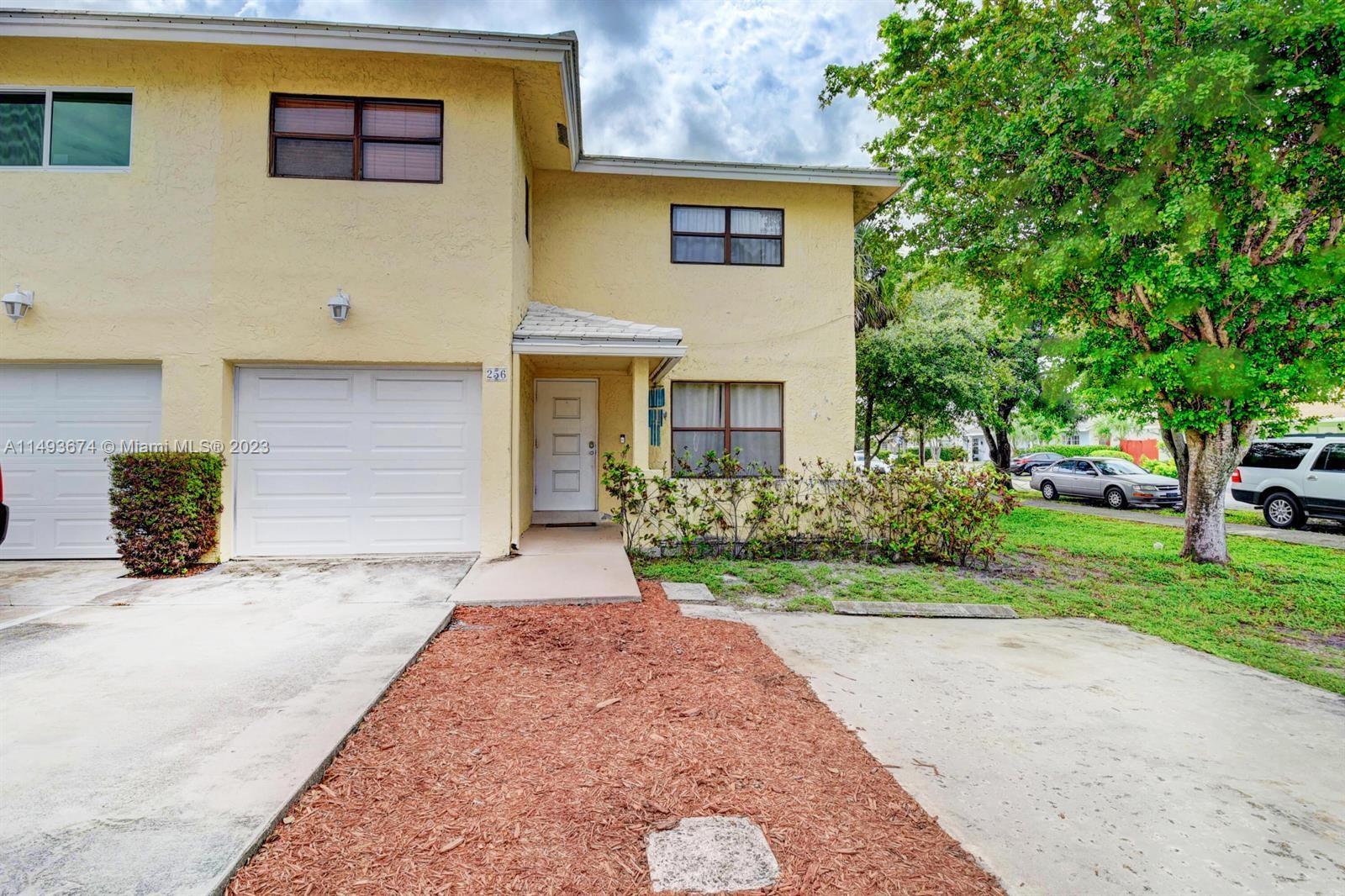 256 Southwest 6th Street, Unit 6 Boca Raton, FL 33432 - Photo 1 of 39 a front view of a house with garden