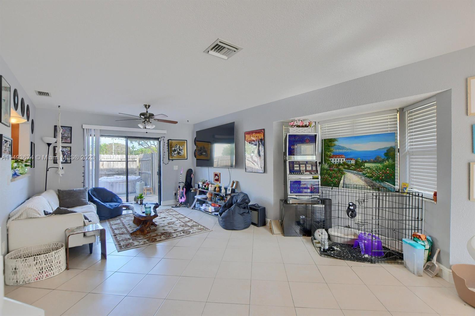 256 Southwest 6th Street, Unit 6 Boca Raton, FL 33432 - Photo 12 of 39 a living room with furniture toys and a flat screen tv