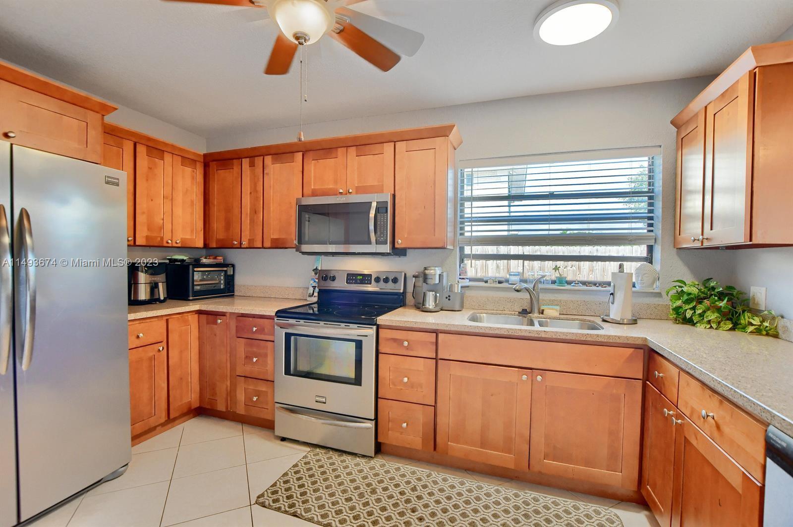 256 Southwest 6th Street, Unit 6 Boca Raton, FL 33432 - Photo 18 of 39 a kitchen with stainless steel appliances granite countertop a sink a stove a refrigerator cabinets and a window