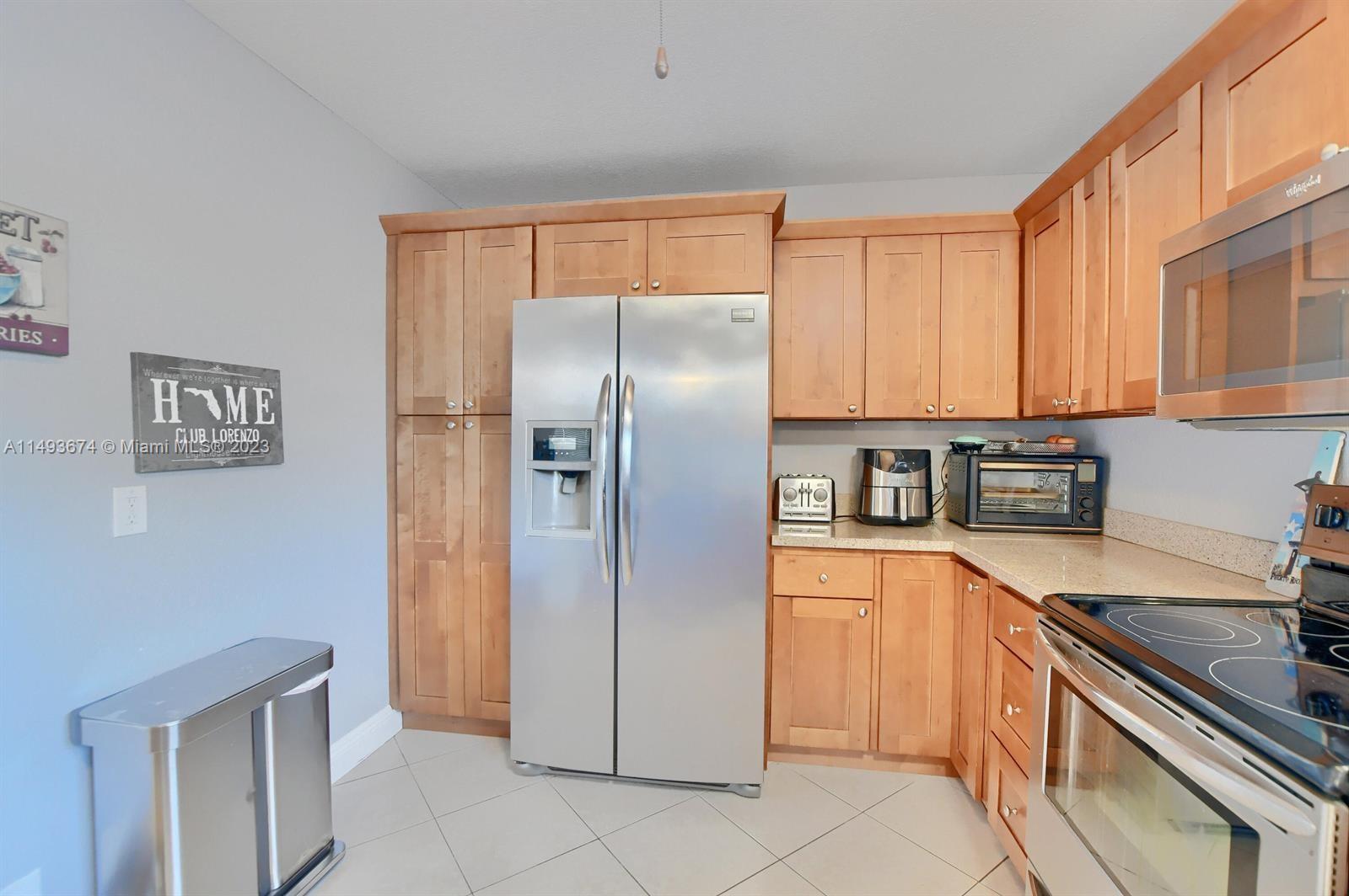 256 Southwest 6th Street, Unit 6 Boca Raton, FL 33432 - Photo 19 of 39 a kitchen with stainless steel appliances granite countertop a refrigerator and a stove top oven