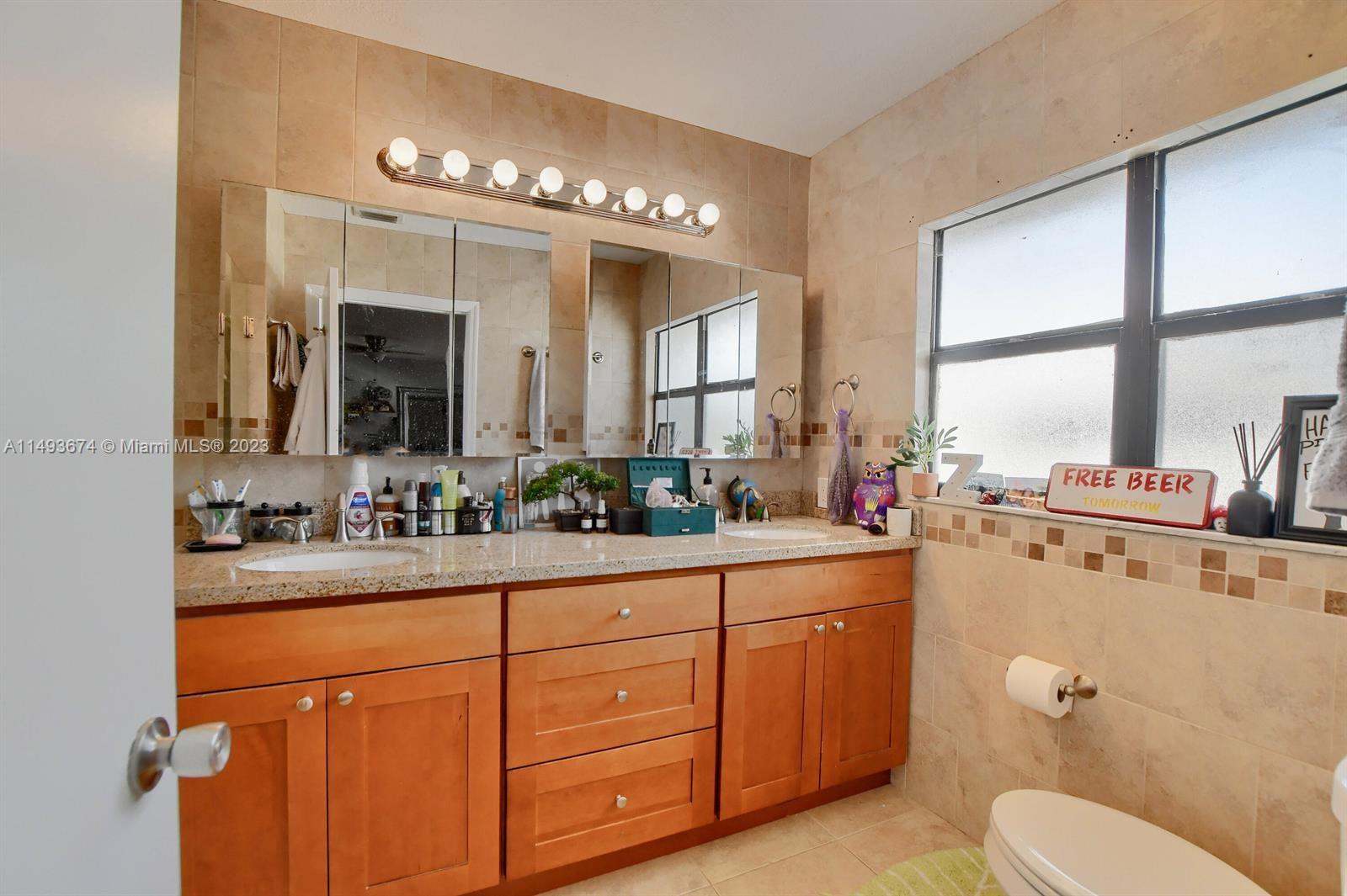 256 Southwest 6th Street, Unit 6 Boca Raton, FL 33432 - Photo 28 of 39 a bathroom with a toilet sink and mirror