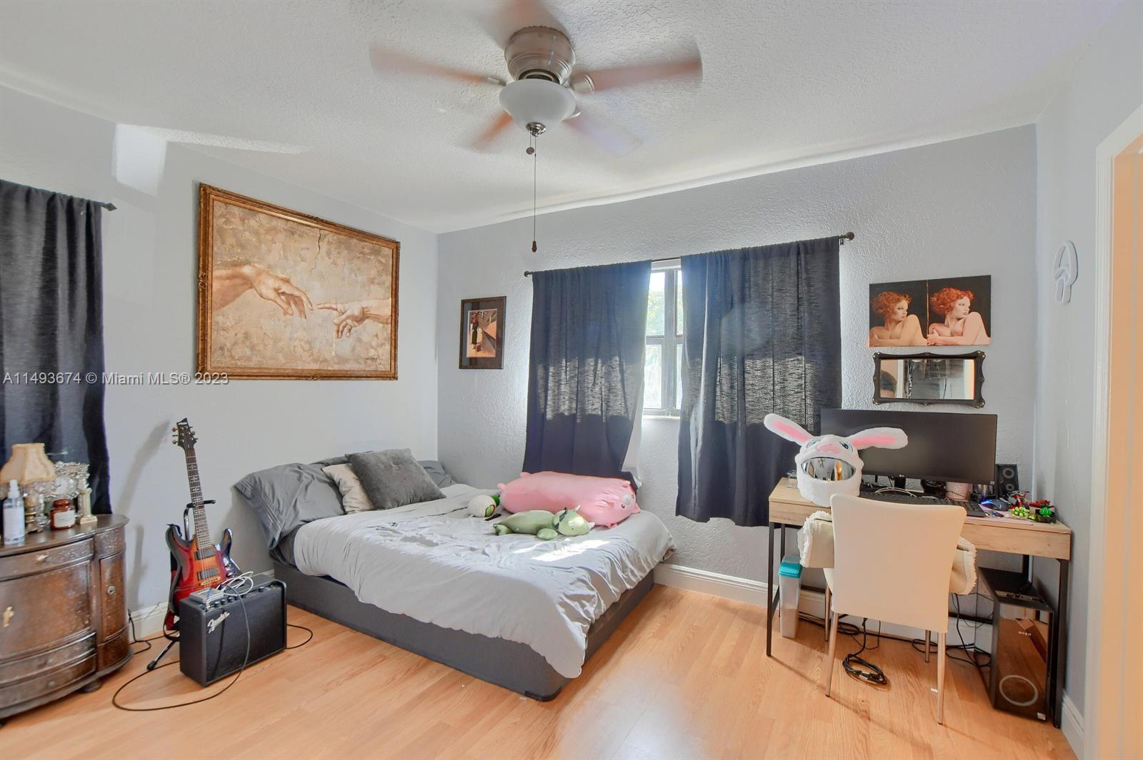 256 Southwest 6th Street, Unit 6 Boca Raton, FL 33432 - Photo 29 of 39 a bedroom with a bed and a lamp on dresser
