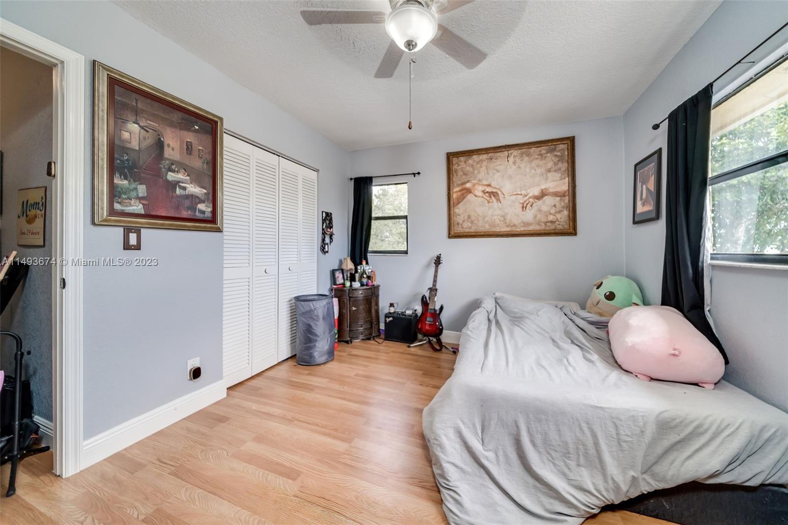 256 Southwest 6th Street, Unit 6 Boca Raton, FL 33432 - Photo 31 of 39 a bedroom with a bed and a painting on the wall