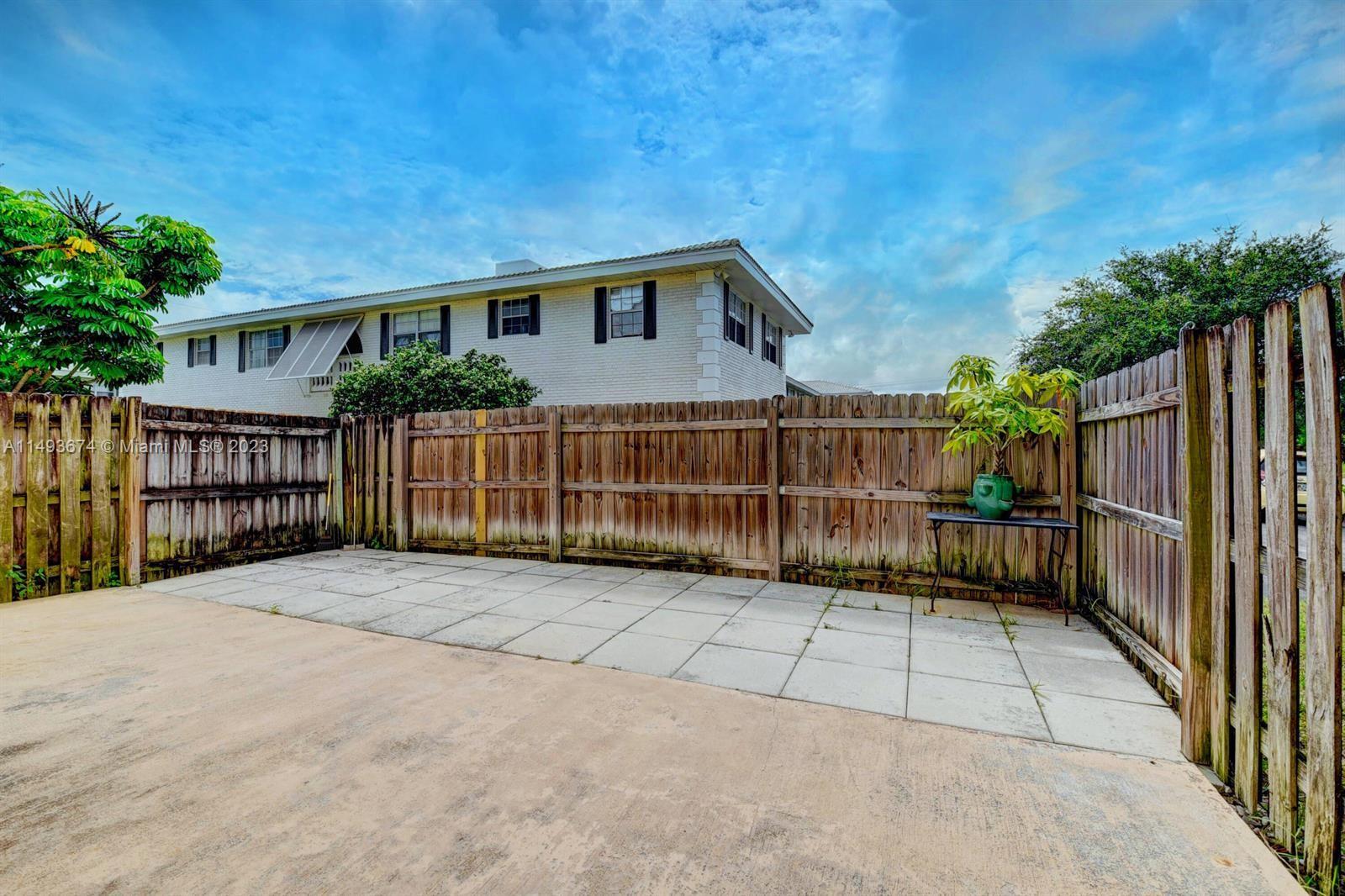 256 Southwest 6th Street, Unit 6 Boca Raton, FL 33432 - Photo 36 of 39 a view of backyard with small garden and wooden fence