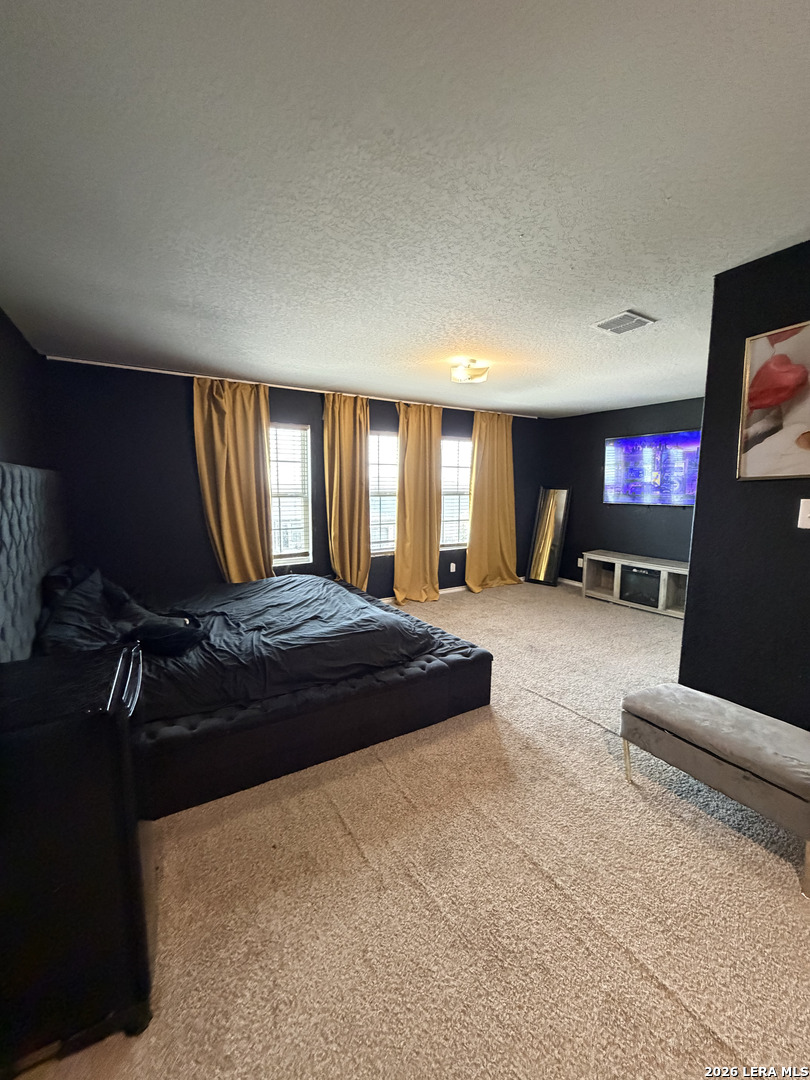 10814 Randolph Way Converse, TX 78109 - Photo 4 of 8 a large bedroom with a bed and large windows