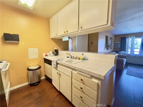 a kitchen with stainless steel appliances a refrigerator a sink a stove and white cabinets