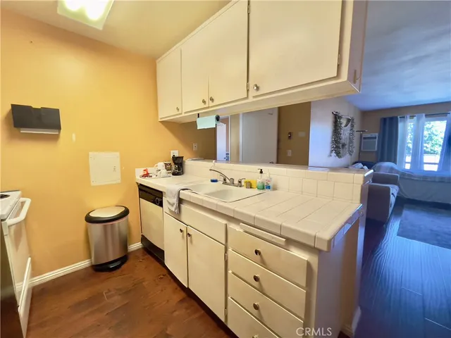 a kitchen with stainless steel appliances a refrigerator a sink a stove and white cabinets