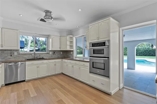 a kitchen with granite countertop a refrigerator and a stove top oven