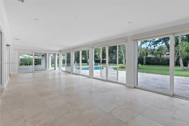 a view of an empty room with wooden floor and garden