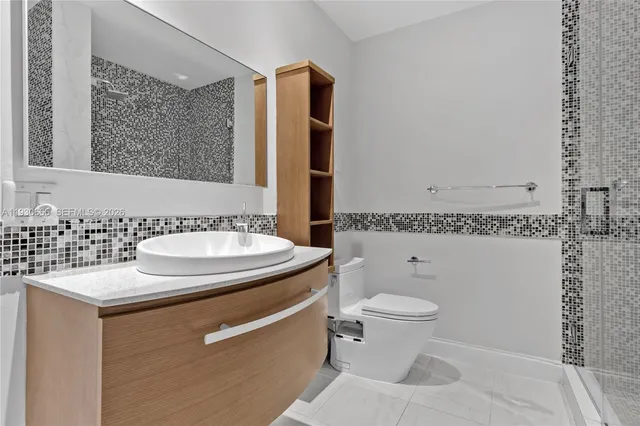 a bathroom with a toilet sink a shower and a mirror