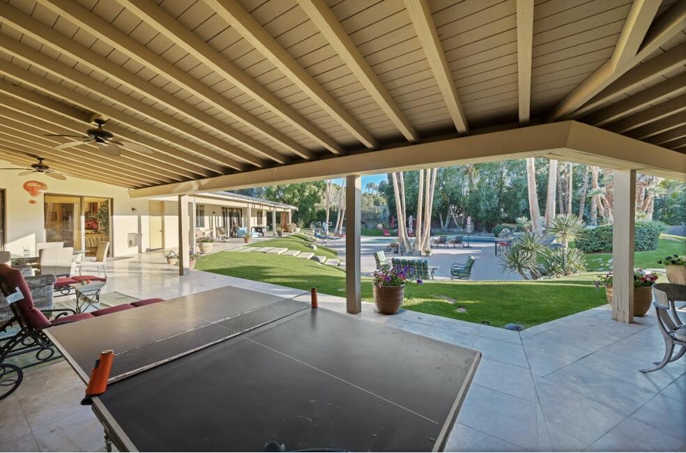 71111 La Paz Road Rancho Mirage, CA 92270 - Photo 37 of 102 a view of a patio with table and chairs potted plants with floor to ceiling window