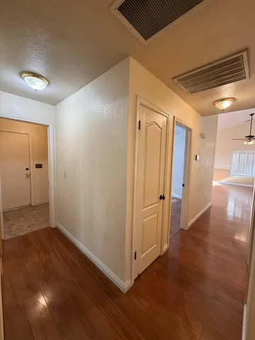 an empty room with wooden floor and a bathroom