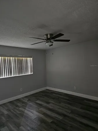 a view of a room with wooden floor and ceiling fan