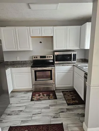 a white kitchen with white cabinets and appliances