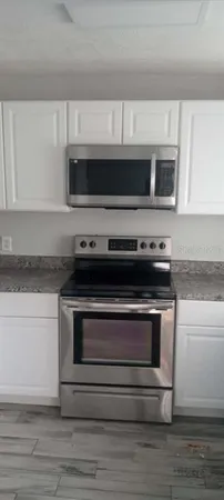 a kitchen with stainless steel appliances granite countertop a stove microwave and oven