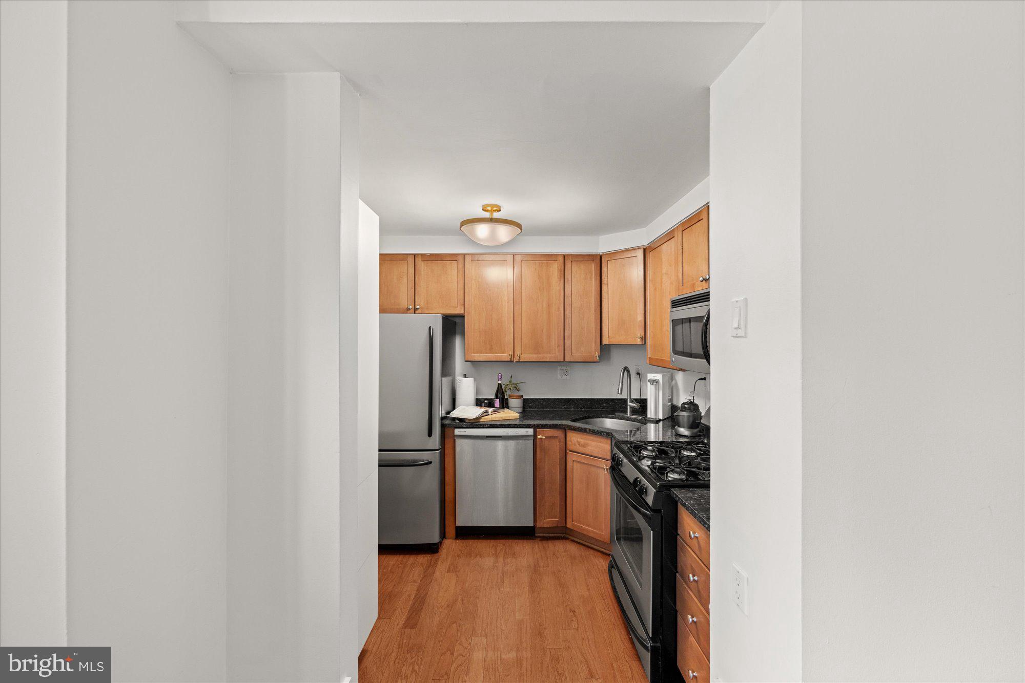 4840 MacArthur Boulevard Northwest, Unit 301 Washington, DC 20007 - Photo 11 of 24 a kitchen with stainless steel appliances a sink stove and refrigerator
