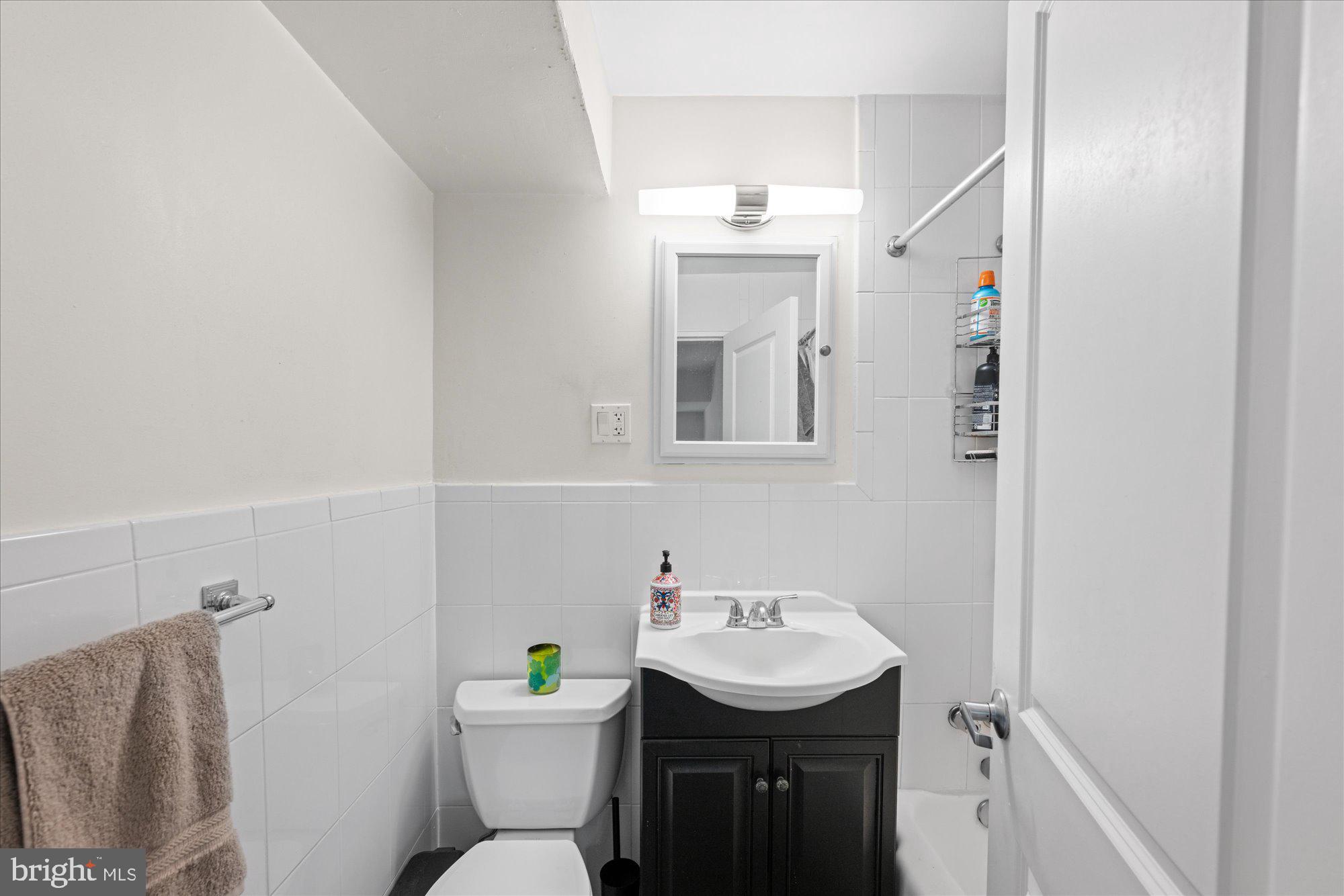 4840 MacArthur Boulevard Northwest, Unit 301 Washington, DC 20007 - Photo 19 of 24 a bathroom with a sink toilet and a mirror