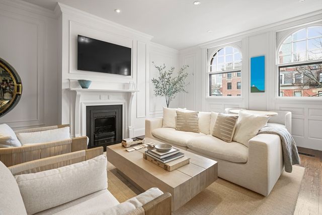 a living room with furniture a flat screen tv and a fireplace