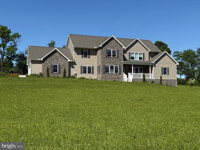 a front view of a house with a yard and trees