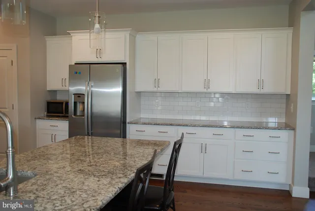 a kitchen with kitchen island a counter top space cabinets and stainless steel appliances