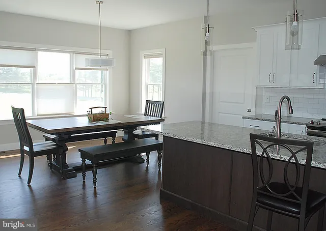 a kitchen with a table chairs and wooden floor